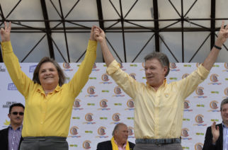 Colombia's President and presidential candidate Juan Manuel Santos (R) and Clara Lopez (L), former presidential candidate of the Alternative Democratic Pole party, raise their arms   during a campaign rallty in Bogota, on June 5, 2014. Santos, elected for the period 2010-2014, will run against the candidate of the Democratic Center party Oscar Ivan Zuluaga in the presidential run-off on June 15. AFP PHOTO/Diana Sanchez / AFP PHOTO / DIANA SANCHEZ